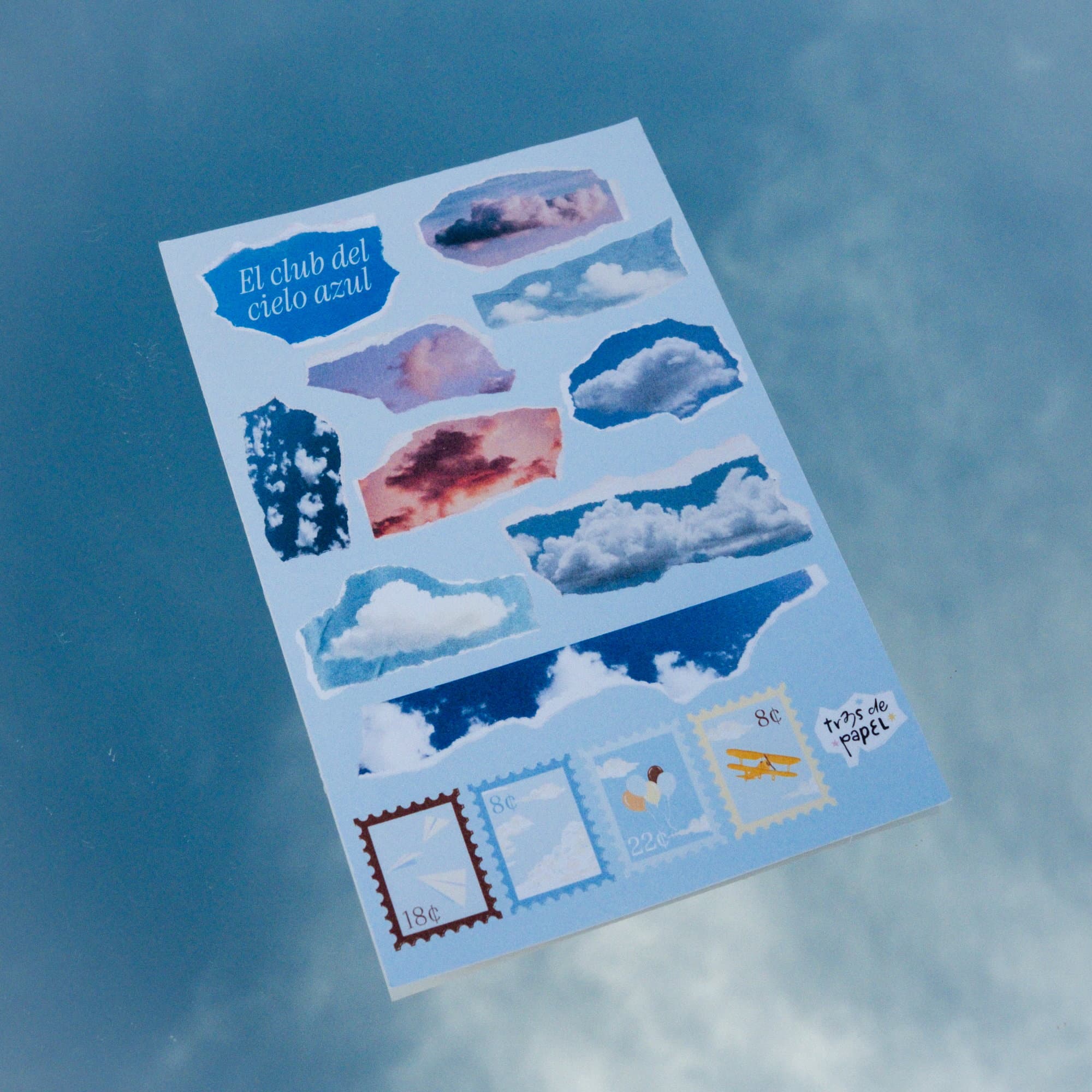 Sticker sheet from the El club del cielo azul kit, with cut-out clouds and illustrated stamps.