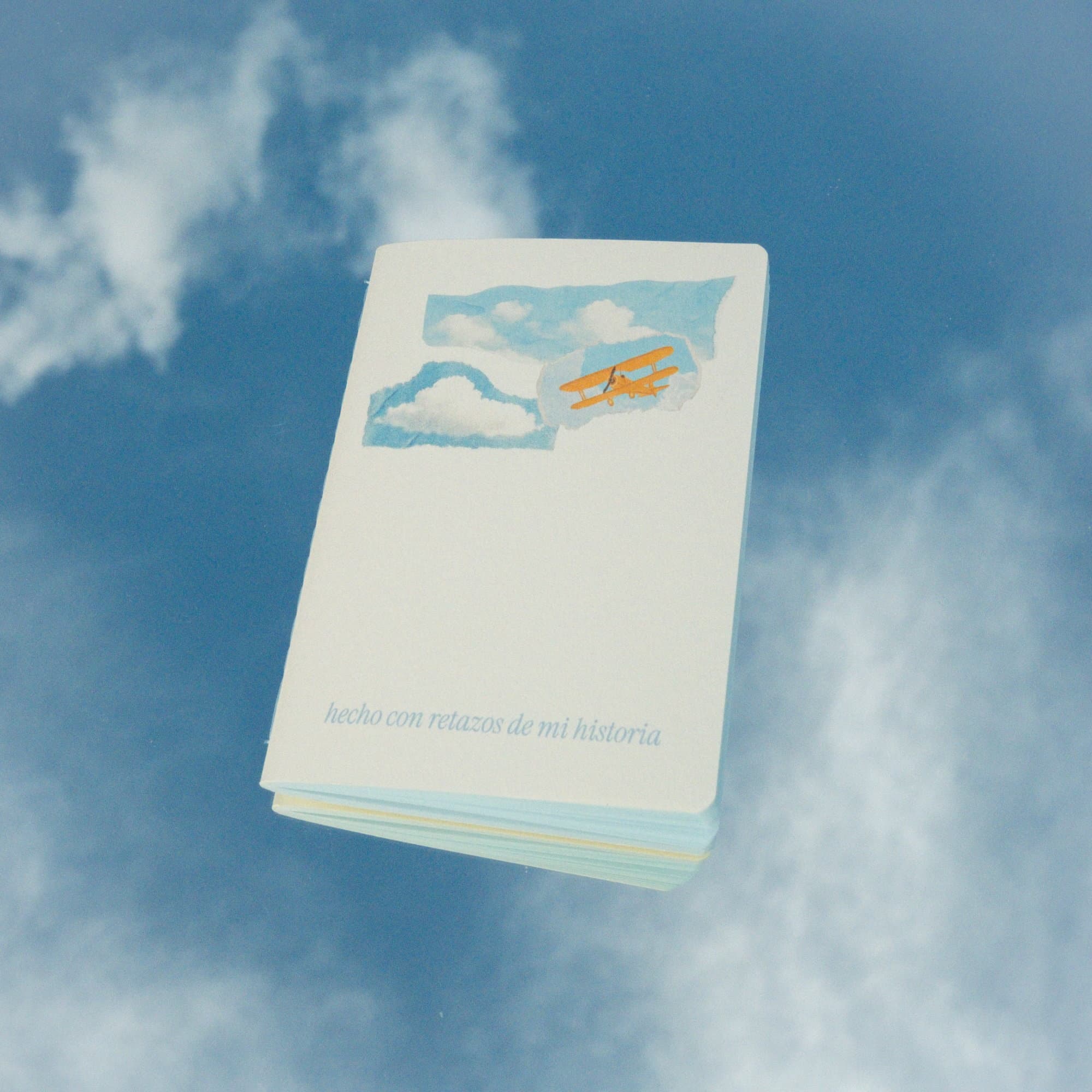 Pocket notebook from the El club del cielo azul kit, with clouds and a plane illustrated on the cover.