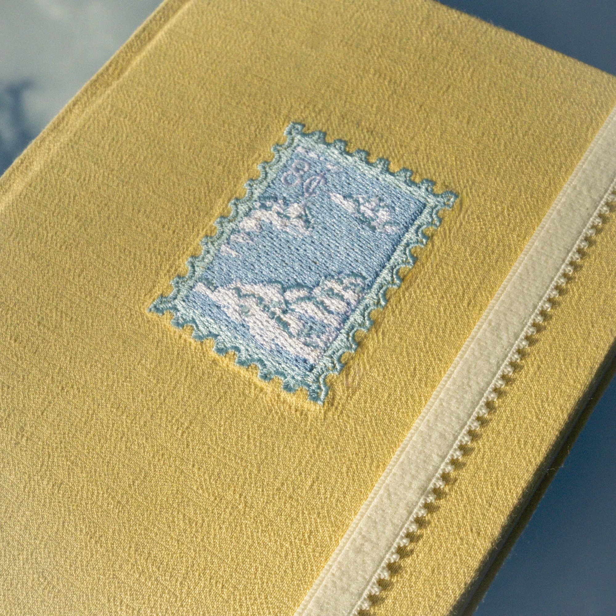 Close-up of the embroidered clouds on the cover of the Entre nubes journal.