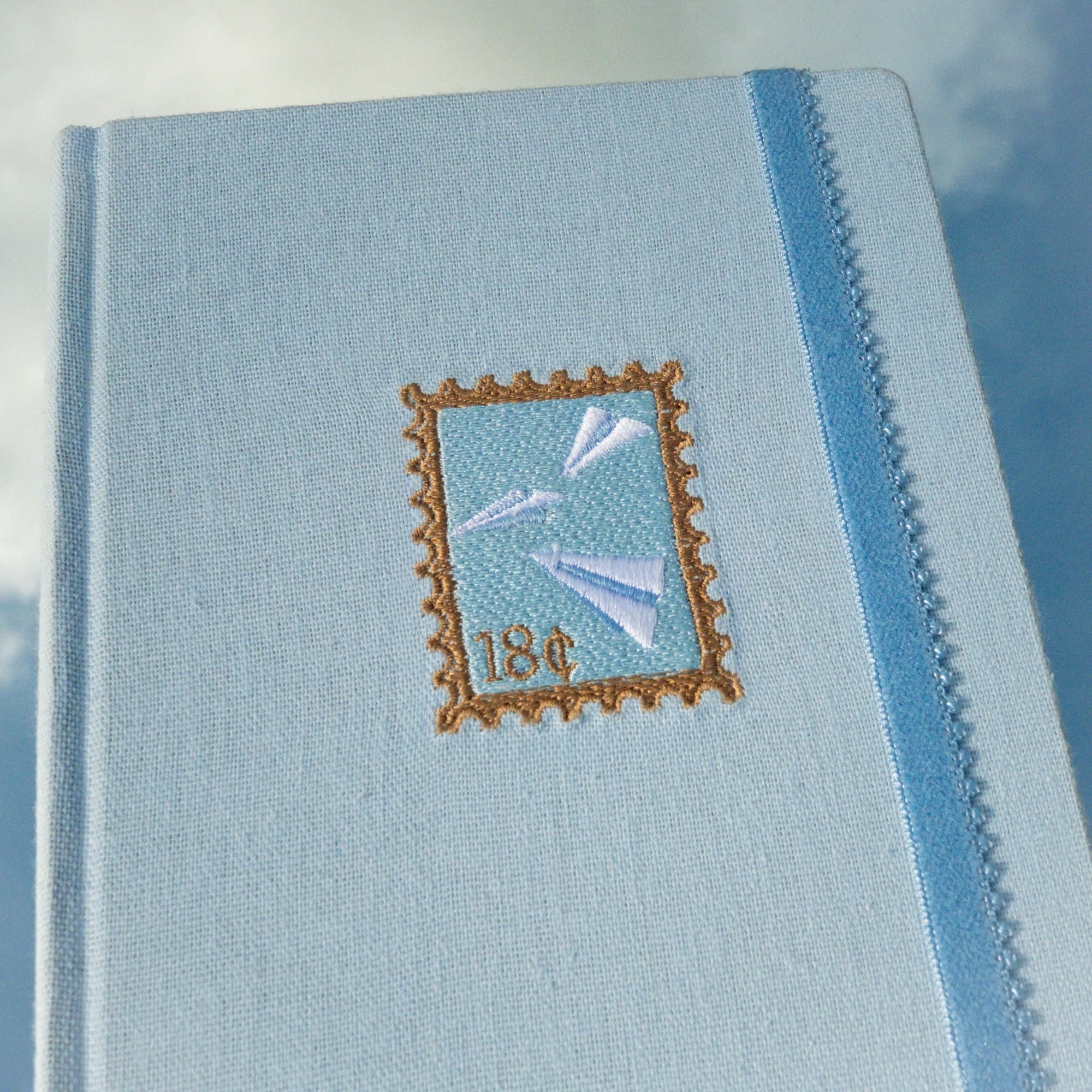 Close-up of the embroidered stamp on the cover of the Trazos de cielo journal.